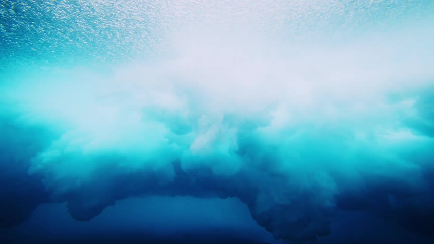 A swirling mass of turbulent light blue water and foam against a backdrop of deeper darker blue