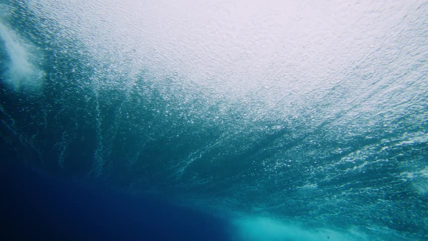 Underwater view in the ocean with a strong tubular wave passing by