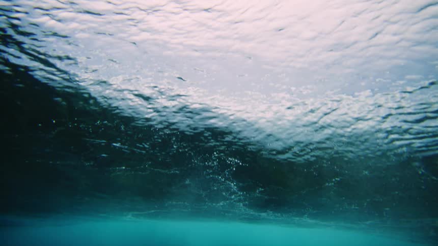 Underwater view in the ocean with a tubular wave breaking