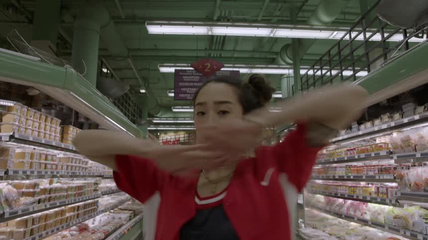 Woman dancing in the middle of a grocery store aisle