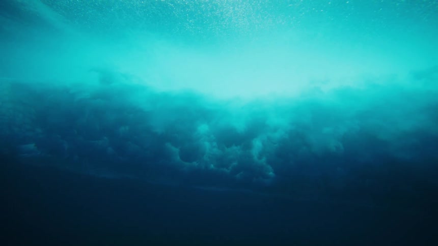 A large wave crashes and falls underwater