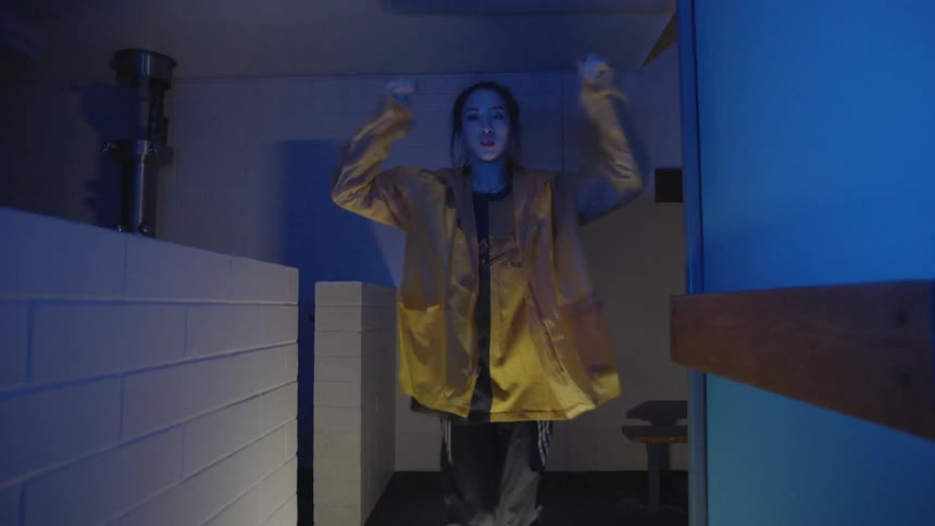 Woman performing some funky dance moves in a dimly lit area