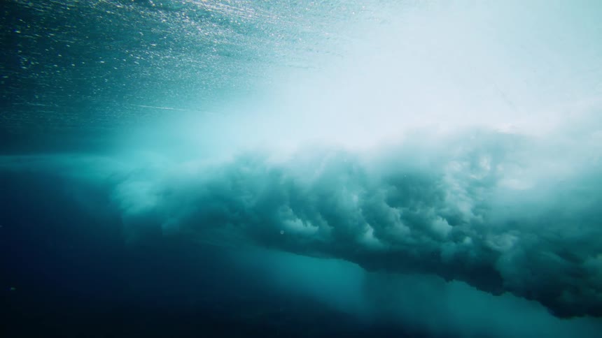 View from inside the ocean with crystal clear waters and a wave breaking