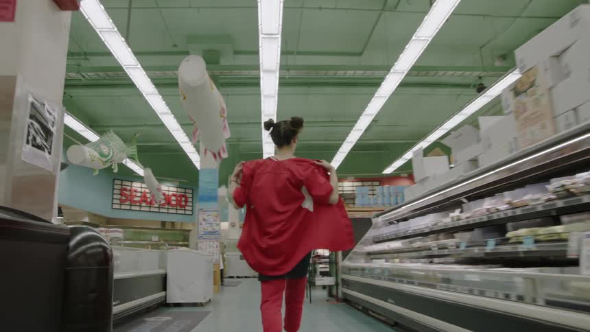 Woman walking down an aisle in a grocery store