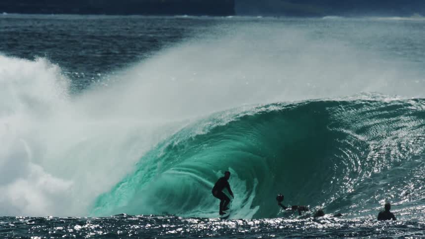 Man surfing a turquoise blue tubular wave