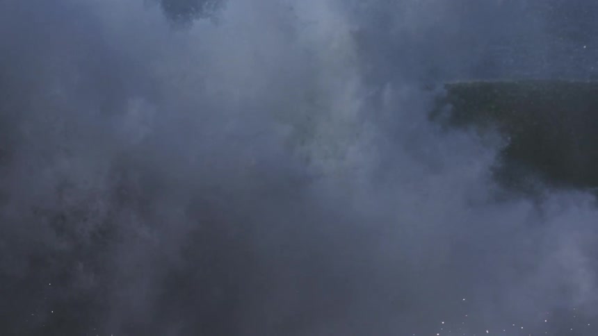 A large wave crashes in front of a person