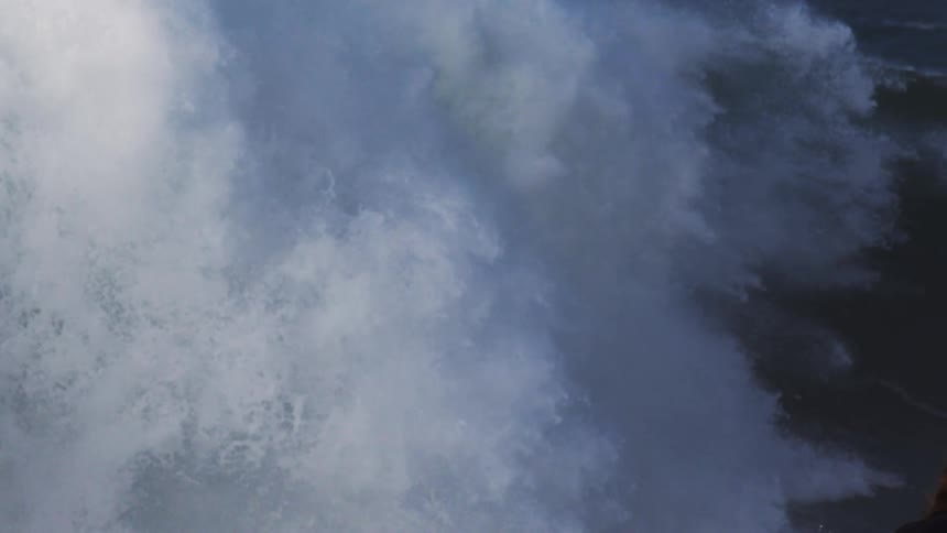 Surfer riding a big tubular wave with pressure and power