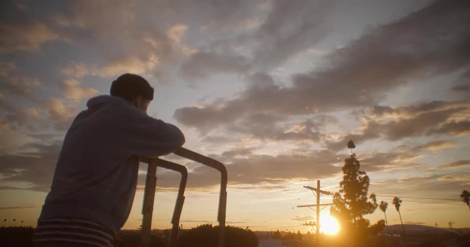 A teenager is watching the sun rise