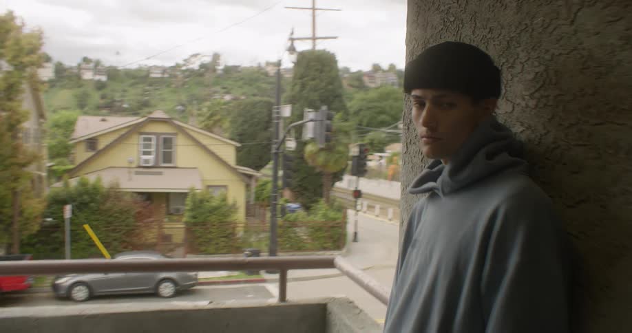 A teenager stands in the hallway by the terrace