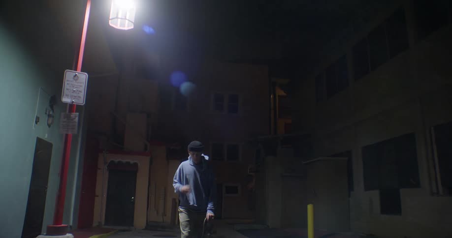Man skateboarding at night down an alley