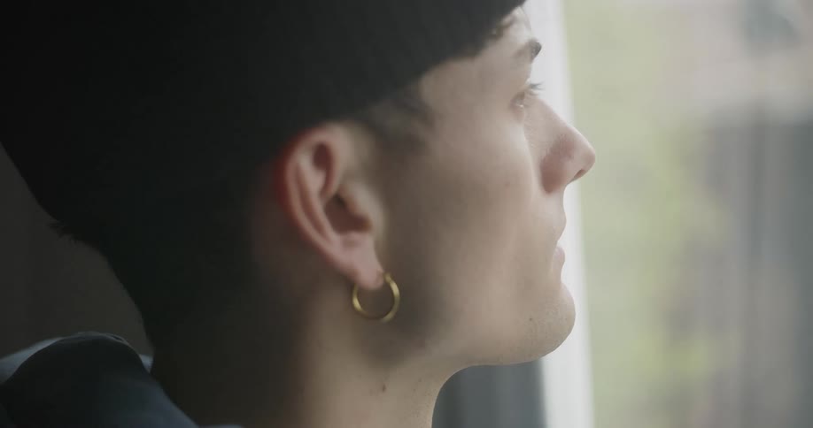 Side portrait of a man looking out the window thoughtfully