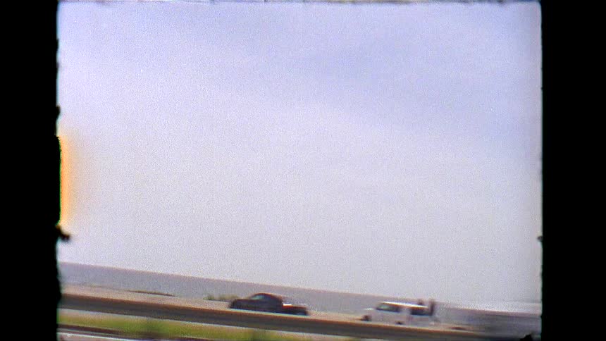 Traffic is traveling on the highway by the beach