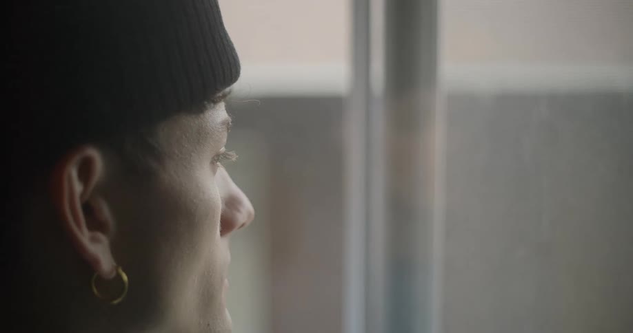 A teenager is looking out the window