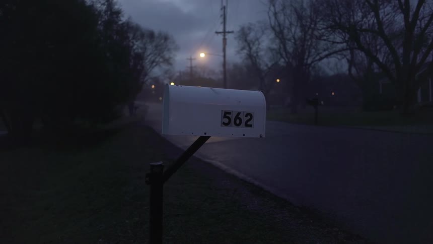 Close up of a mailbox near a street at night