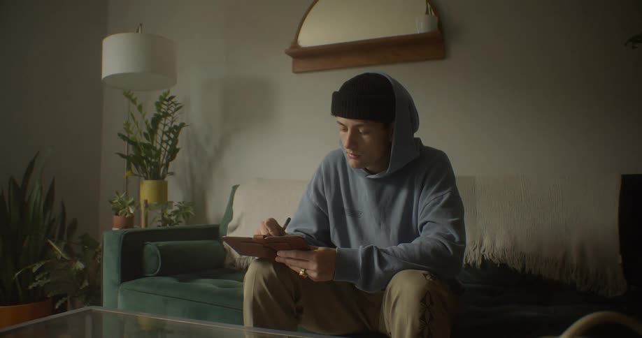 A teenager is writing on a clipboard