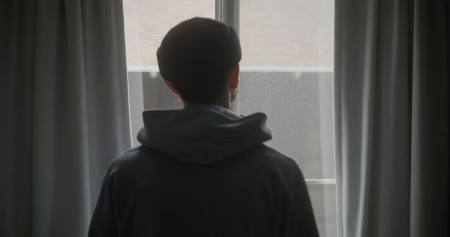 Person in a room looking out the window