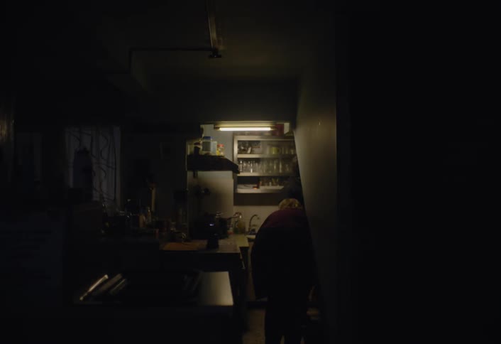 A woman walks into the kitchen where a man is boiling water