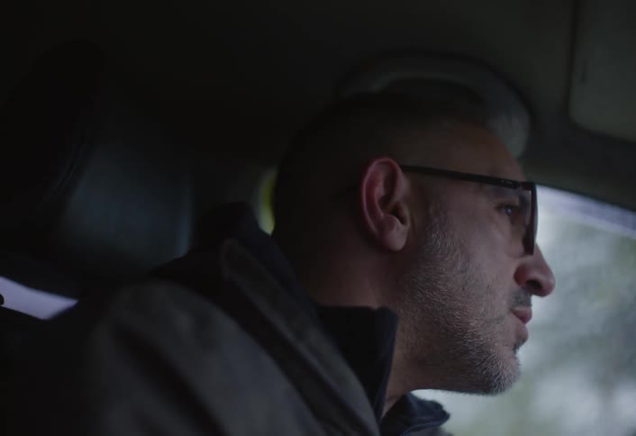 Closeup of a man driving an automobile on a cloudy autumn day