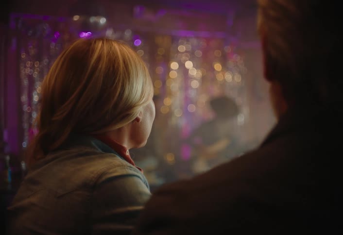 Man and woman sit at a club listening to music