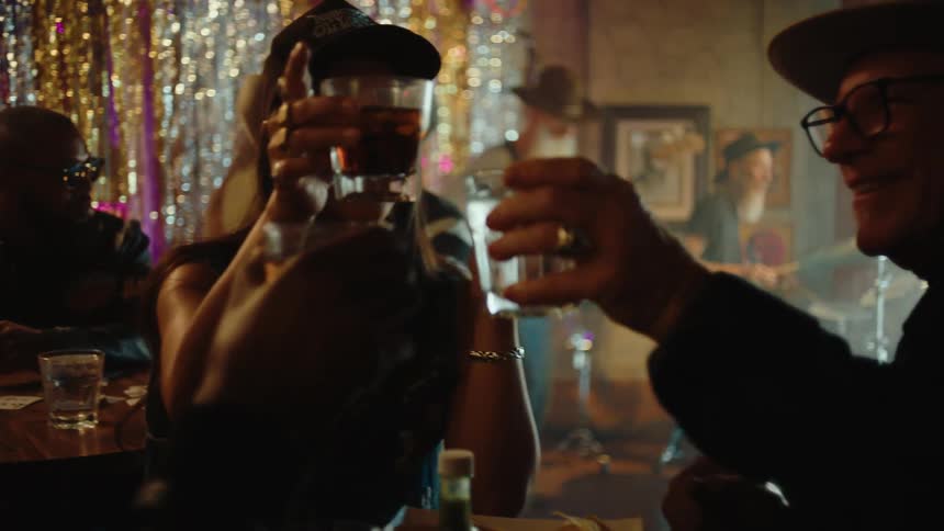 Group of happy people toasting inside a bar with live music