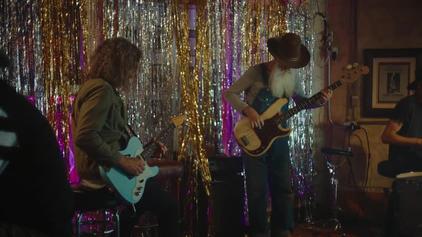 Band plays at a small club while patrons enjoy themselves