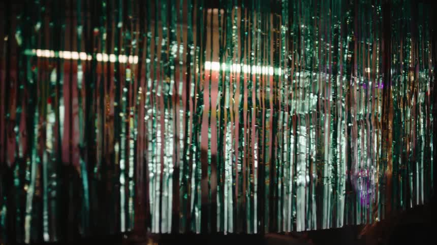 Tinsel curtain obscures people attending a club