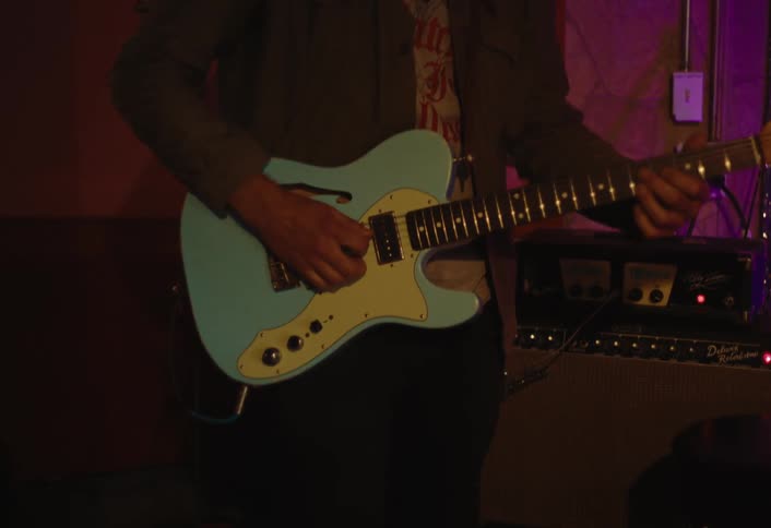 A man is playing a bass guitar
