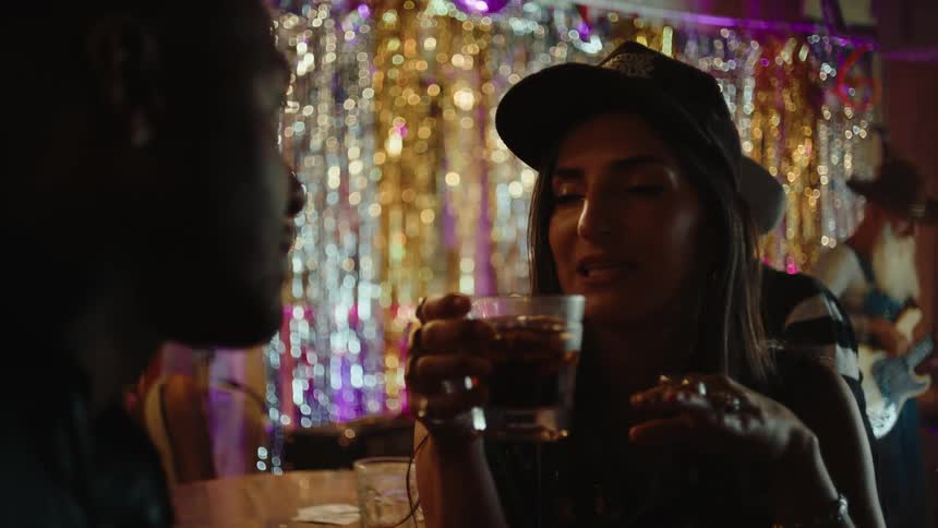 A woman is talking with a man while drinking in the club