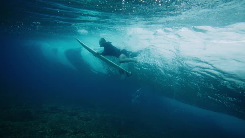 Underwater view of a surfer riding a wave