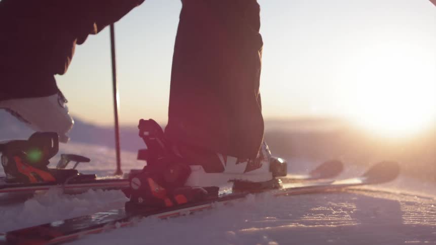 A skier snaps their boots into skis