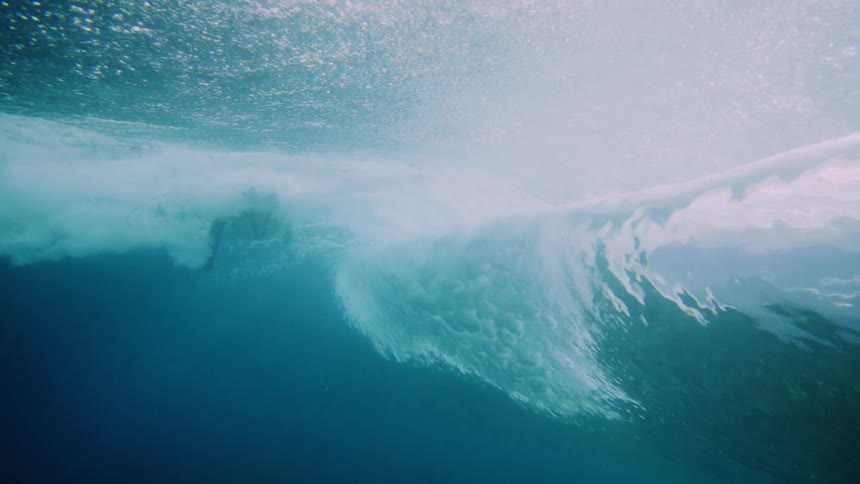 A man is surfing in the blue water