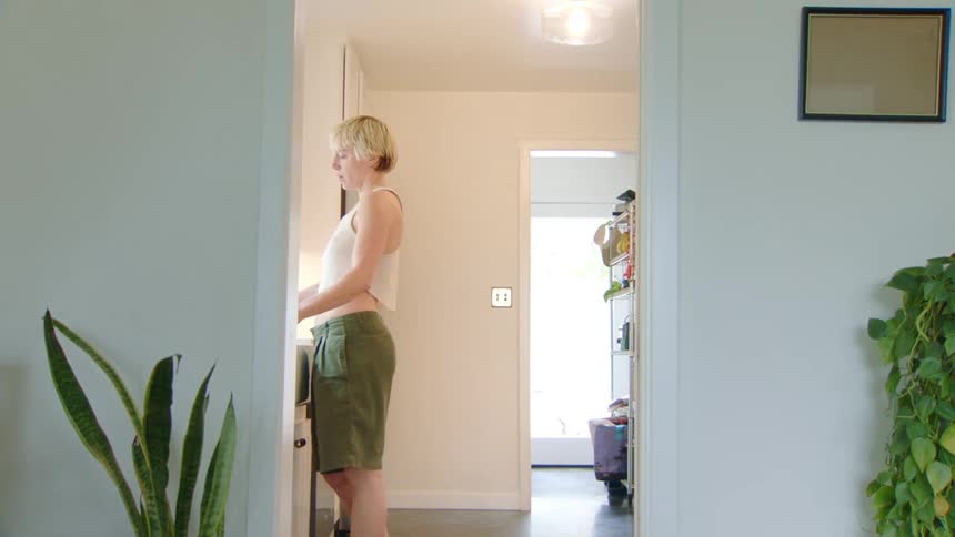 Person standing in the kitchen washes an utensil