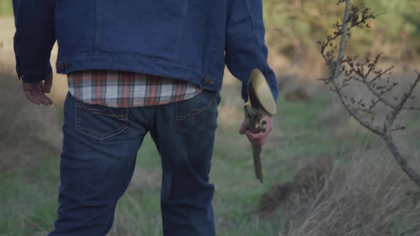 Man walking with a shotgun in the woods