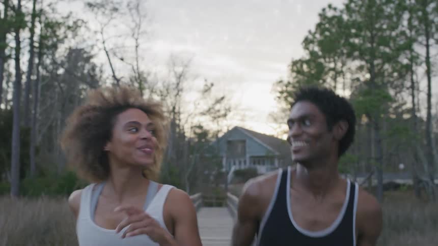 A man and woman jog and talk