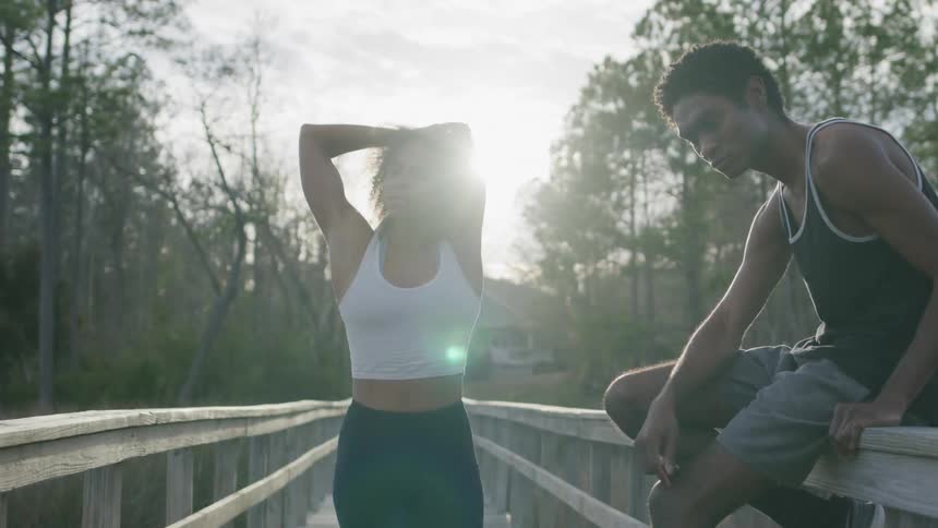 A man and woman are on the wooden walkway