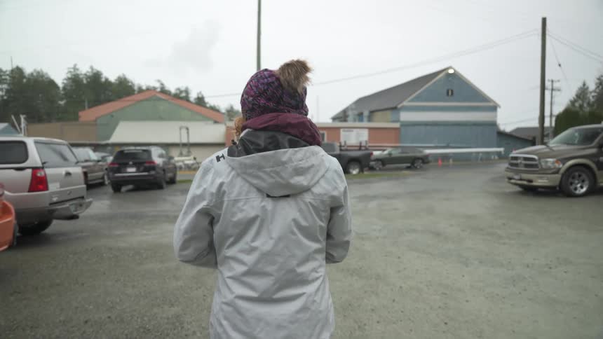 A woman is walking through the parking lot
