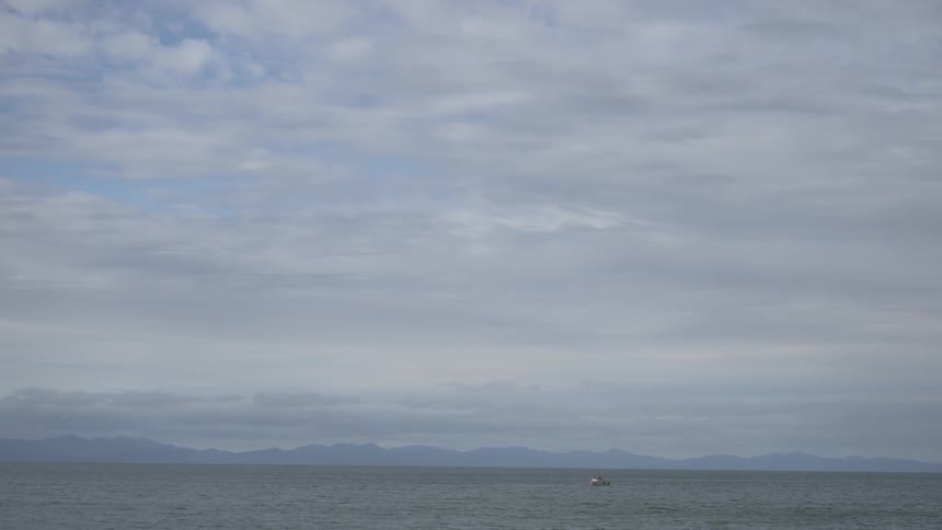 A single boat is out in the ocean