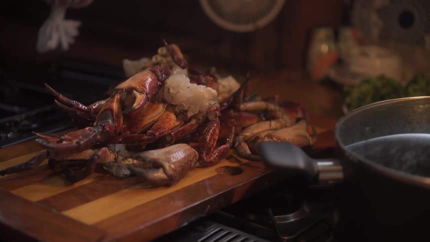 Boneless crab on a wooden board next to a pan