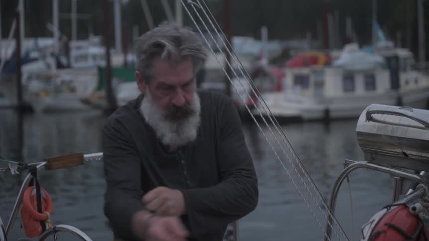 Man inside a boat adjusting a rope