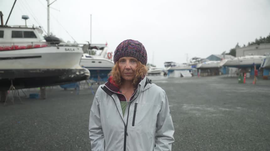 Woman walking near boats on a cloudy day