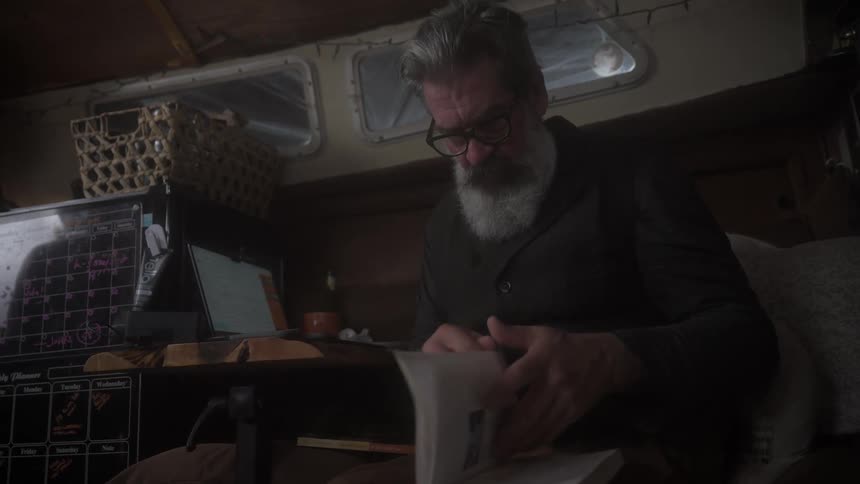 A man sits in a boat and reads