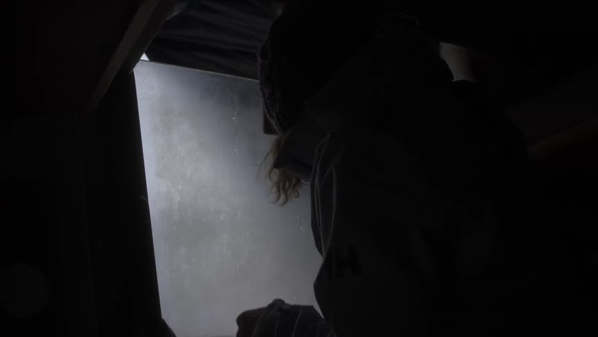 Silhouette of a person closing the window of a boat