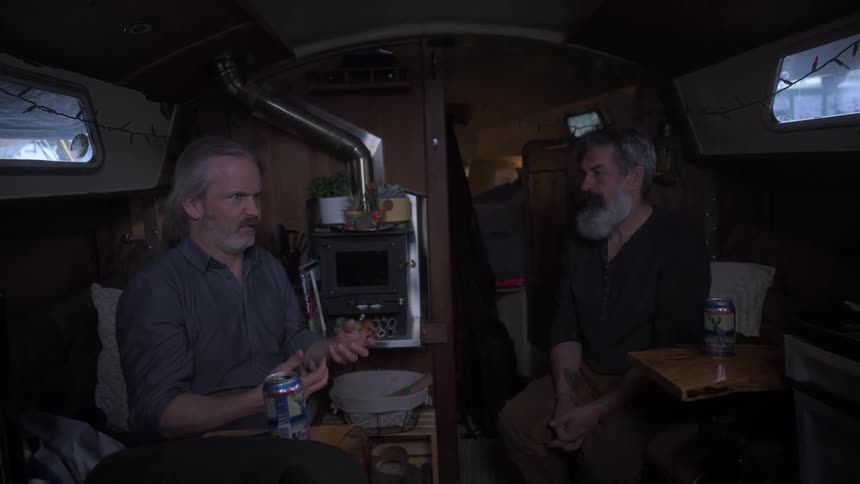 Two men sitting inside a boat talking to each other