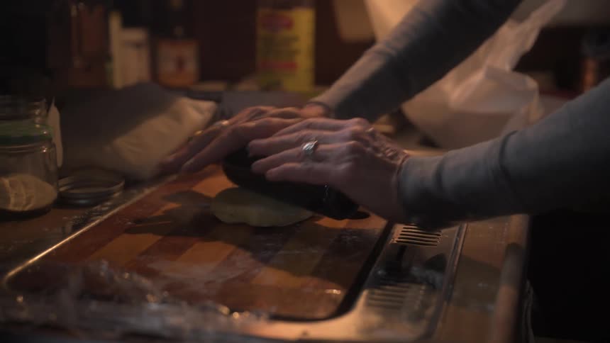 Woman rolling dough on a cutting board