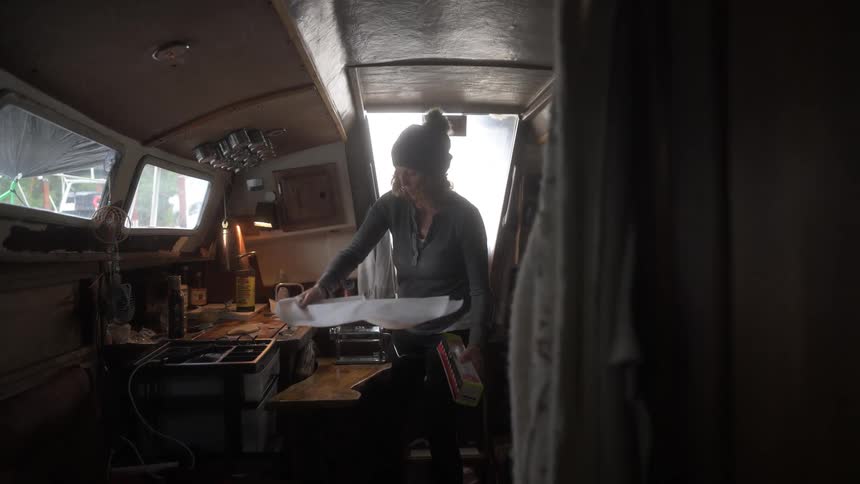 Woman inside a boat cabin cooking