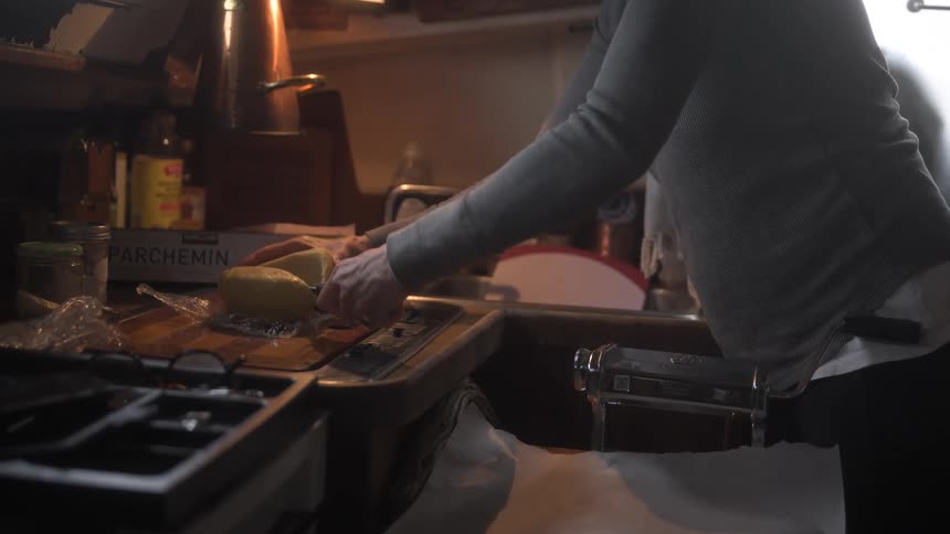 Pair of hands cutting slices of cheese