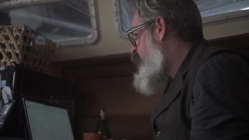 Bearded man working in front of a laptop