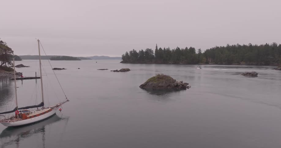 Aerial view of a calm sea with a boat stopped and another one moving in the background on a cloudy day