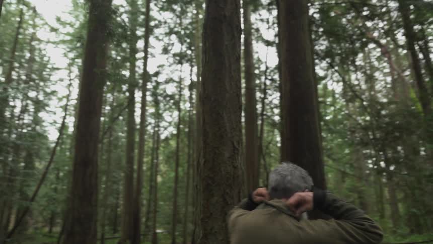 A footage of an elderly man hiking the woods