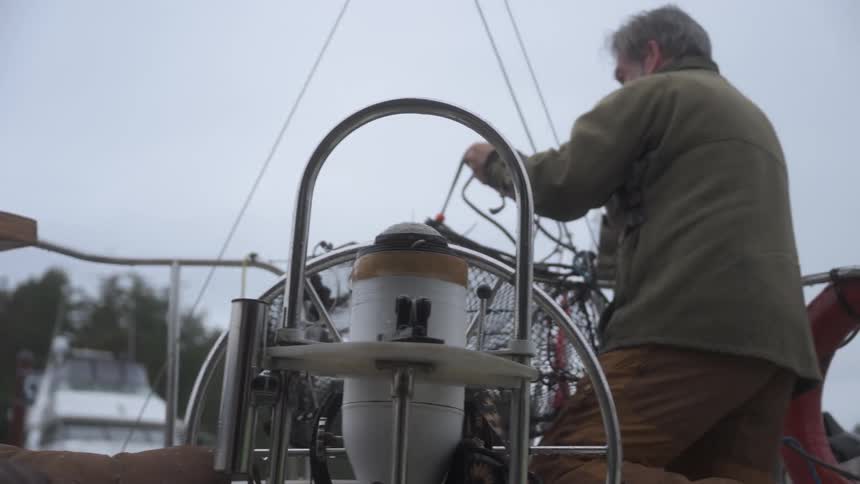 A man lifts a cage with a fish inside on the boat